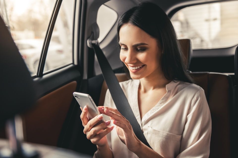 Frau am Handy in Auto
