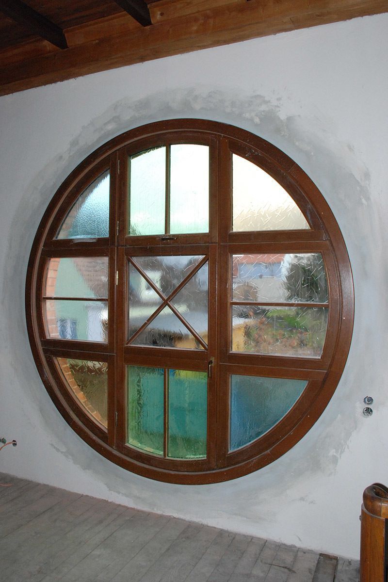 Ein rundes Fenster mit Buntglas in einem Raum
