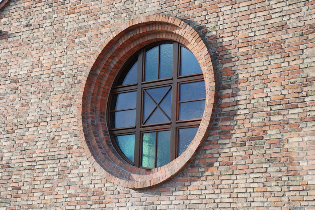 Ein rundes Fenster an der Seite eines Backsteingebäudes