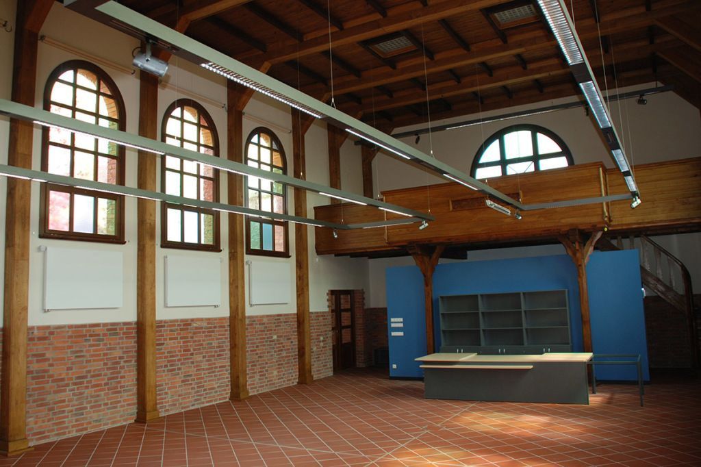 Ein großer leerer Raum mit einem Schreibtisch und Buntglasfenstern