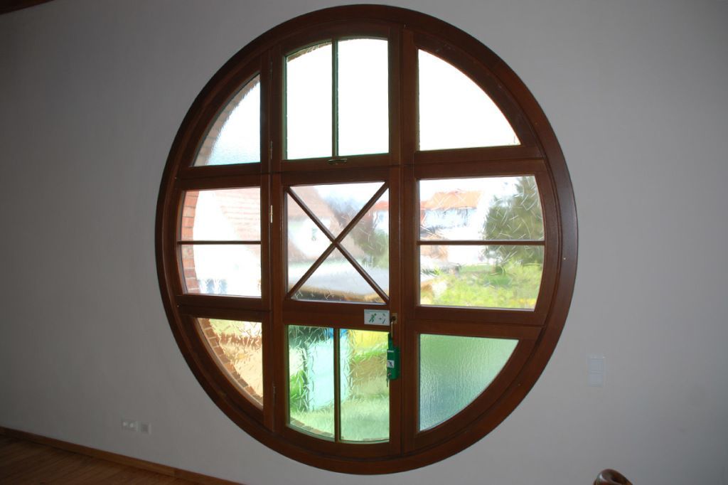 Ein rundes Fenster in einem Raum mit einer weißen Wand