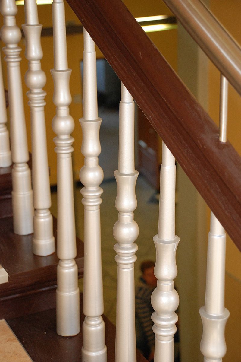 Eine Holztreppe mit weißem Geländer und einem Metallgeländer