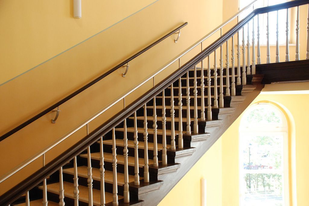 Eine Treppe mit Geländer und Fenster im Hintergrund