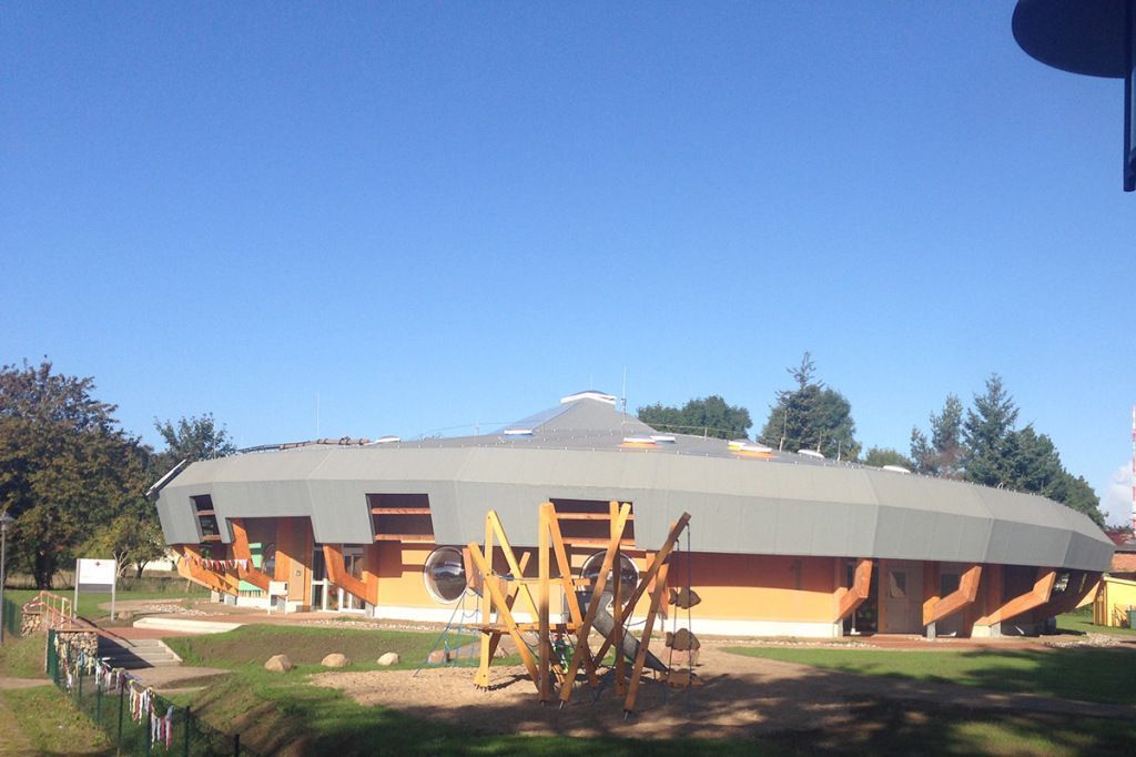 Ein großes Gebäude mit einem Spielplatz davor.