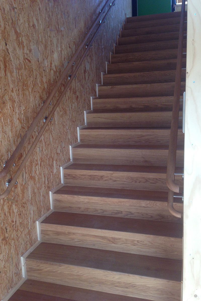 Eine Holztreppe mit Geländer und Holzwand.