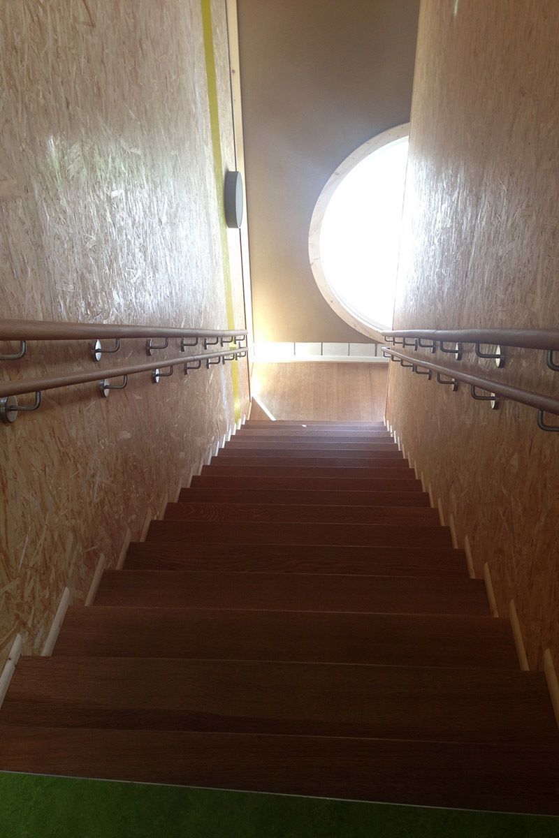 Eine Treppe, die zu einem Fenster in einem Gebäude führt.