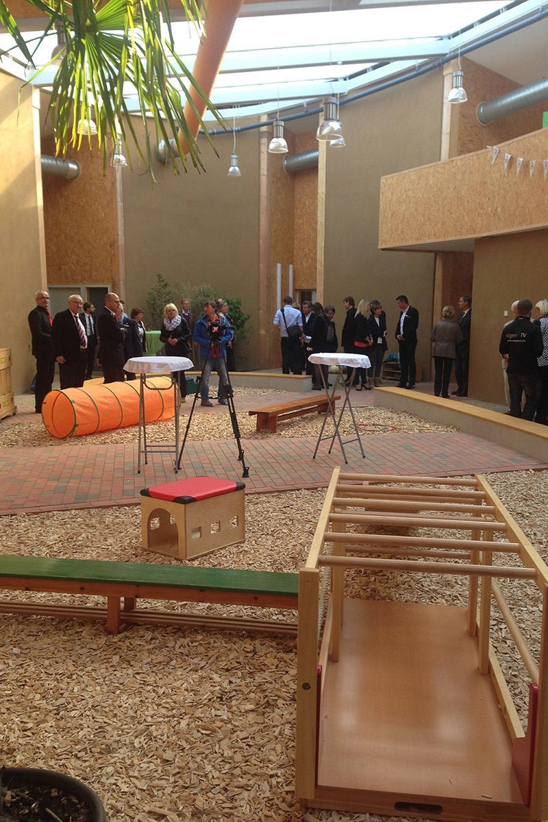 Eine Gruppe von Leuten steht in einem Raum mit Tischen und Stühlen.