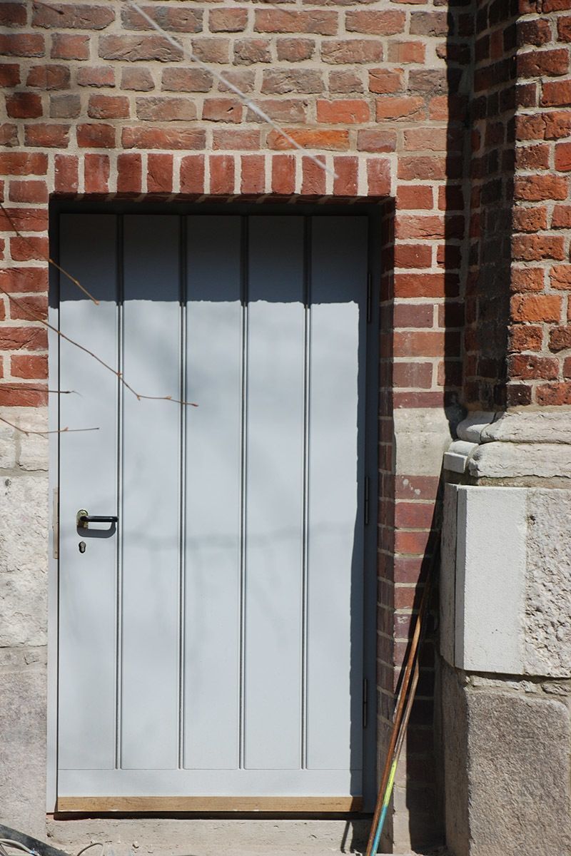 Ein Backsteingebäude mit einer grauen Tür