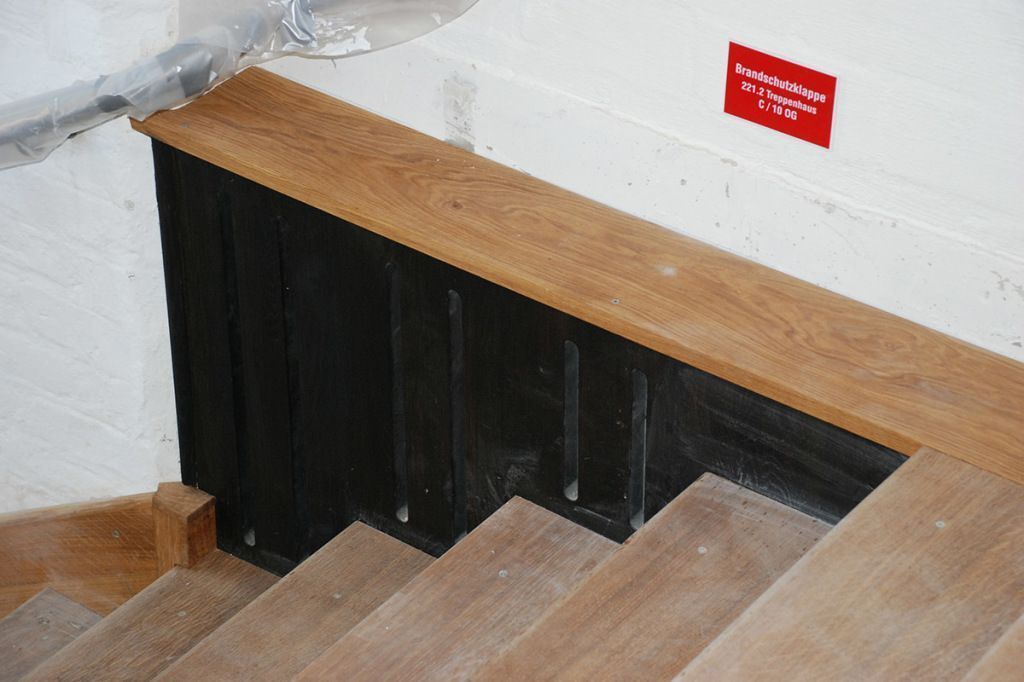 Eine Holztreppe mit einem roten Schild an der Wand