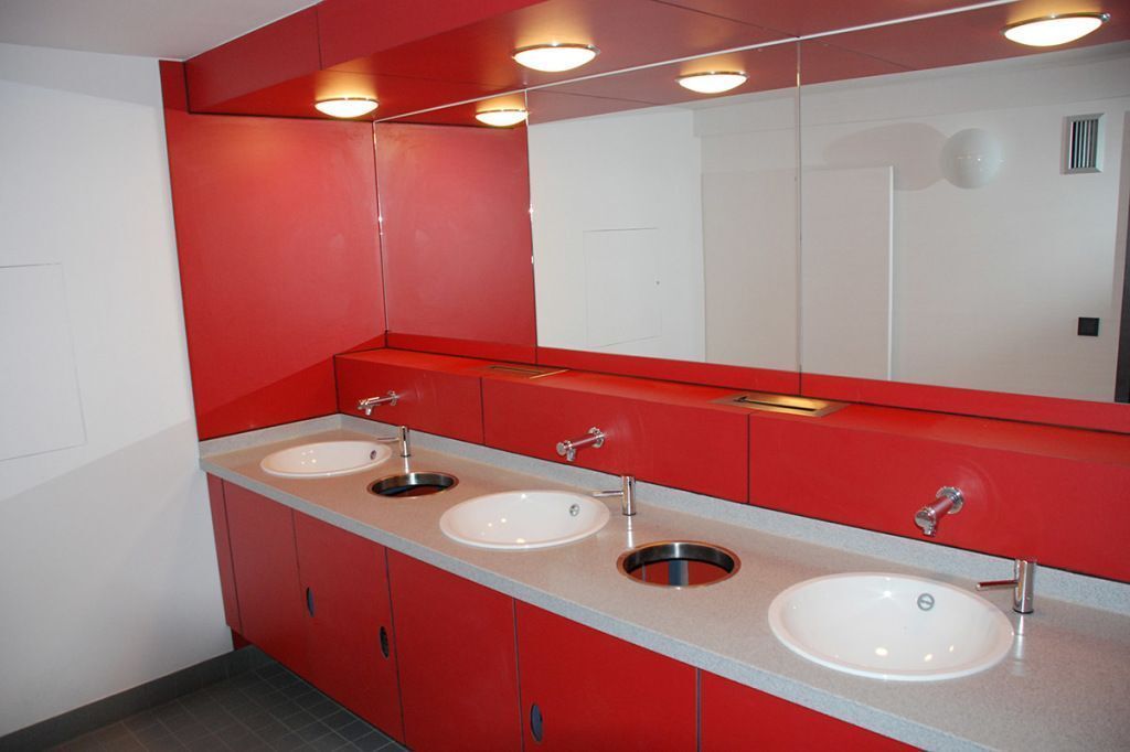 Ein Badezimmer mit drei Waschbecken und einem großen Spiegel