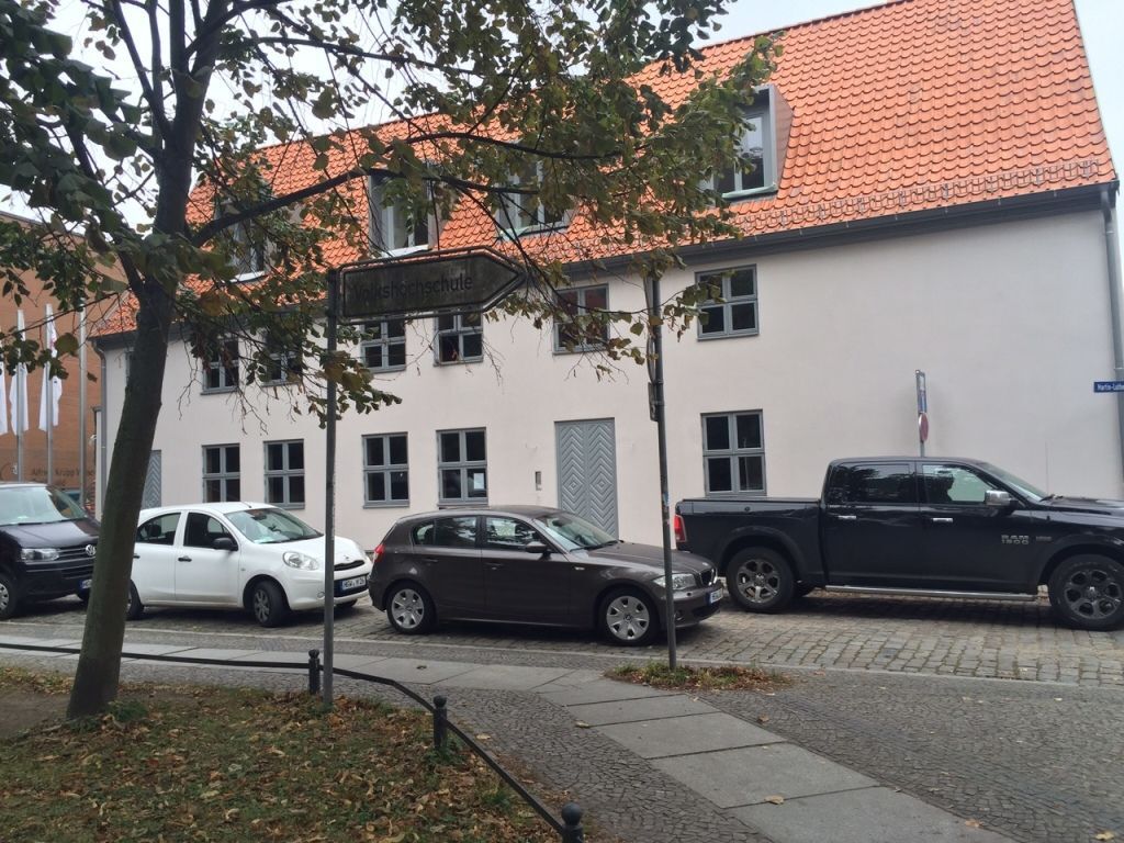 Eine Reihe von Autos parkt vor einem Gebäude