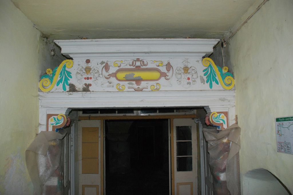 Ein Raum mit einer Tür und einer Decke mit einem Gemälde daran.