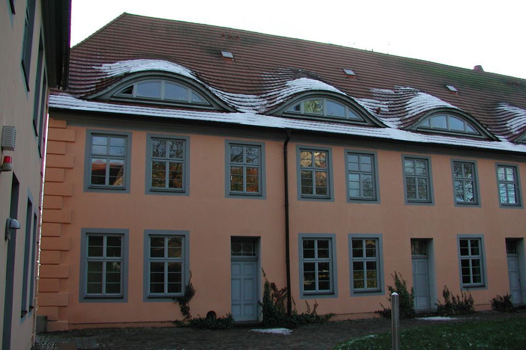 Ein Gebäude mit einem roten Ziegeldach und vielen Fenstern