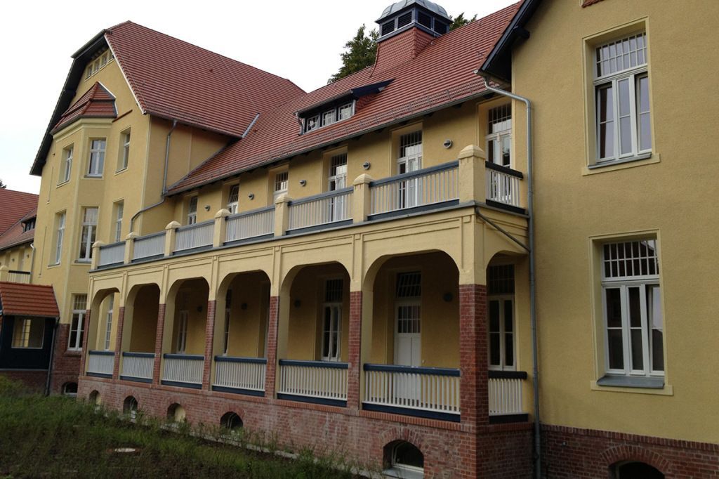 Ein großes gelbes Gebäude mit einem roten Ziegeldach