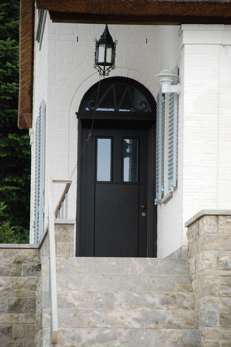 Ein weißes Gebäude mit einer schwarzen Tür und Treppe