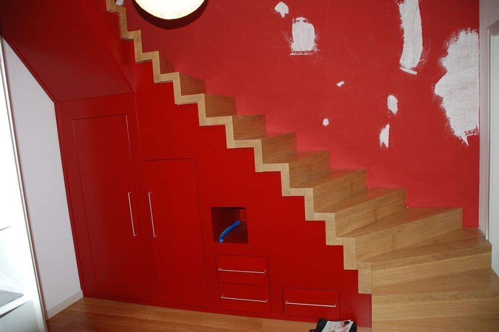 Eine Holztreppe mit einer roten Wand dahinter