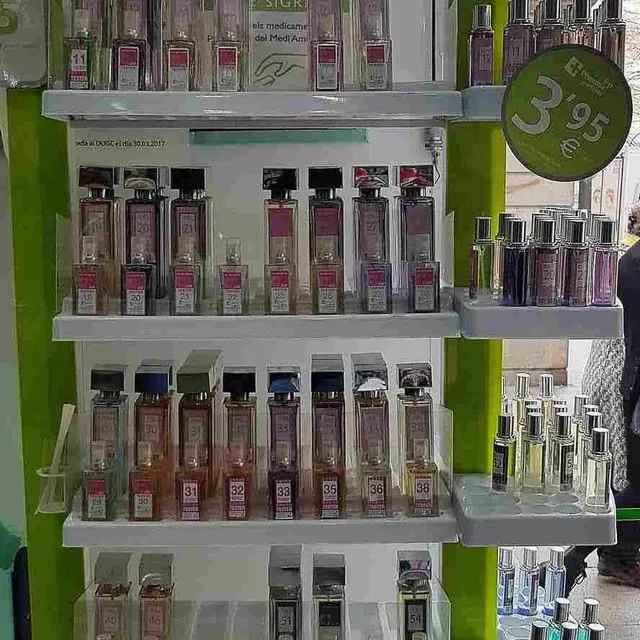 Una exhibición de frascos de perfume en los estantes de una tienda.