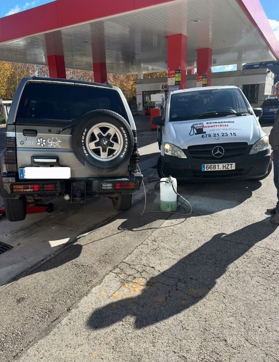 Dos coches están aparcados uno al lado del otro en una gasolinera.