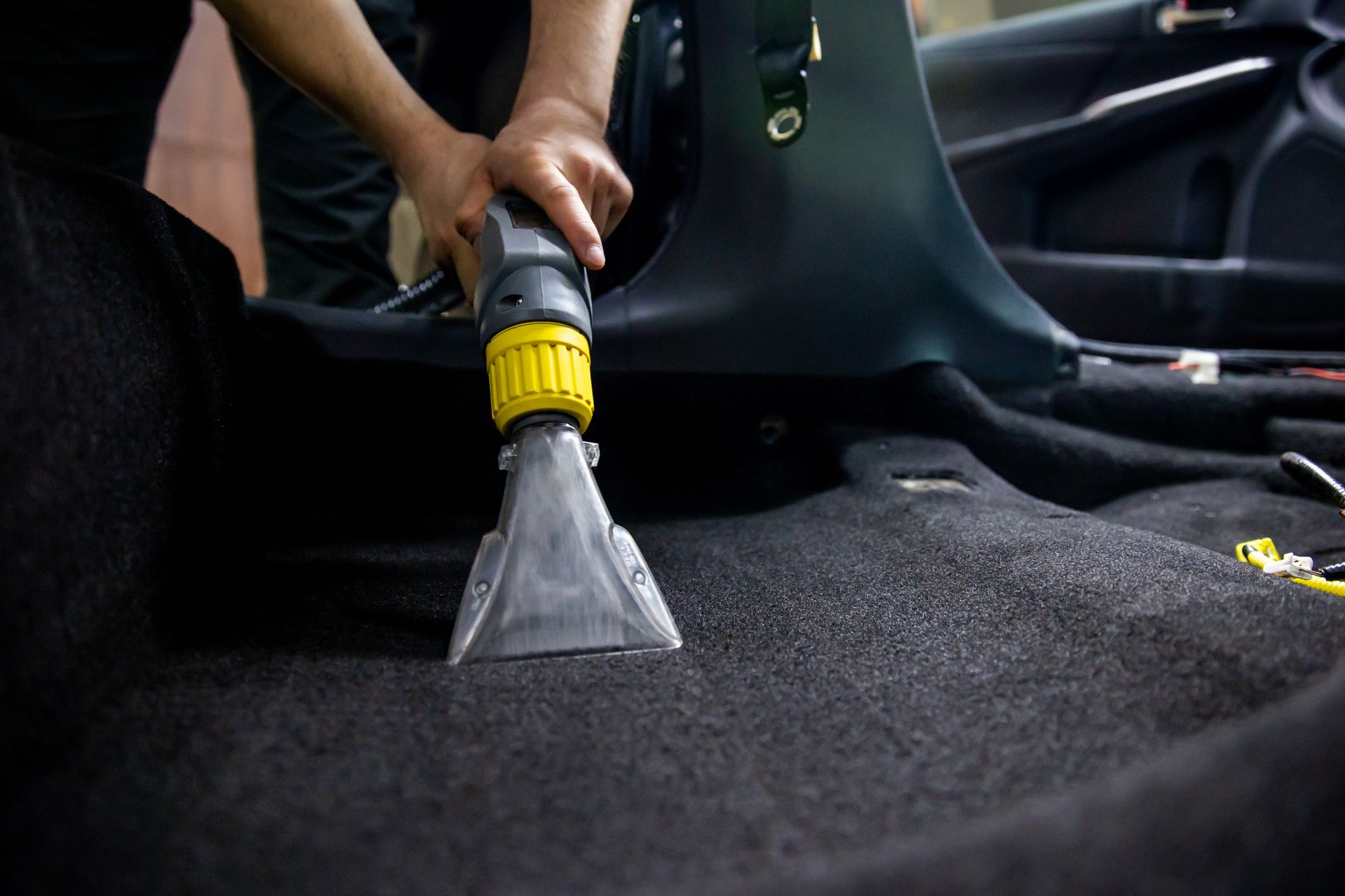 Nettoyage d'un tapis de sol de voiture.