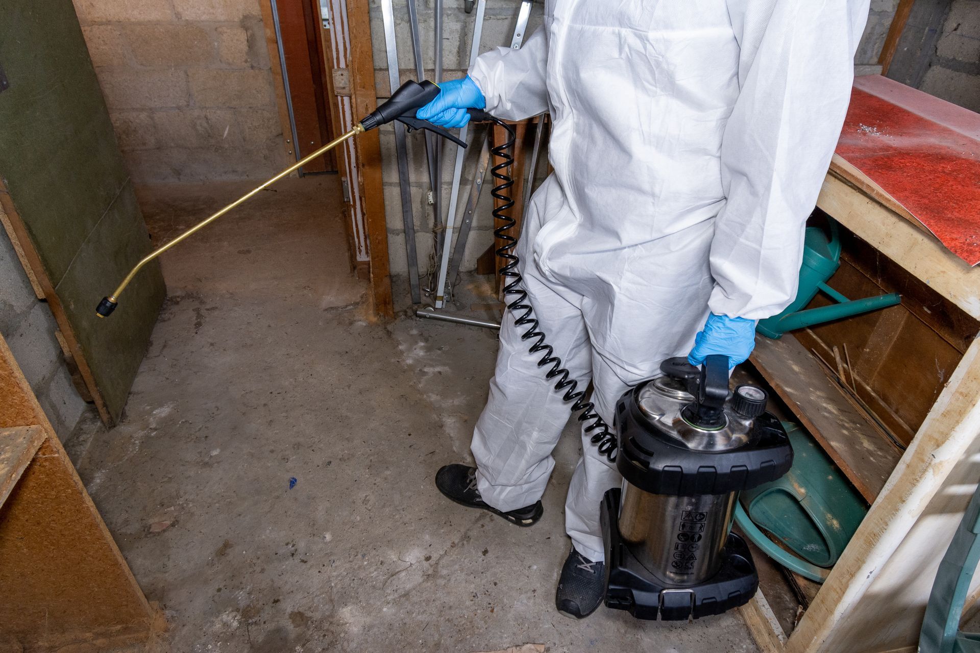 Un professionnel tient un pistolet pour pulvériser du produit.