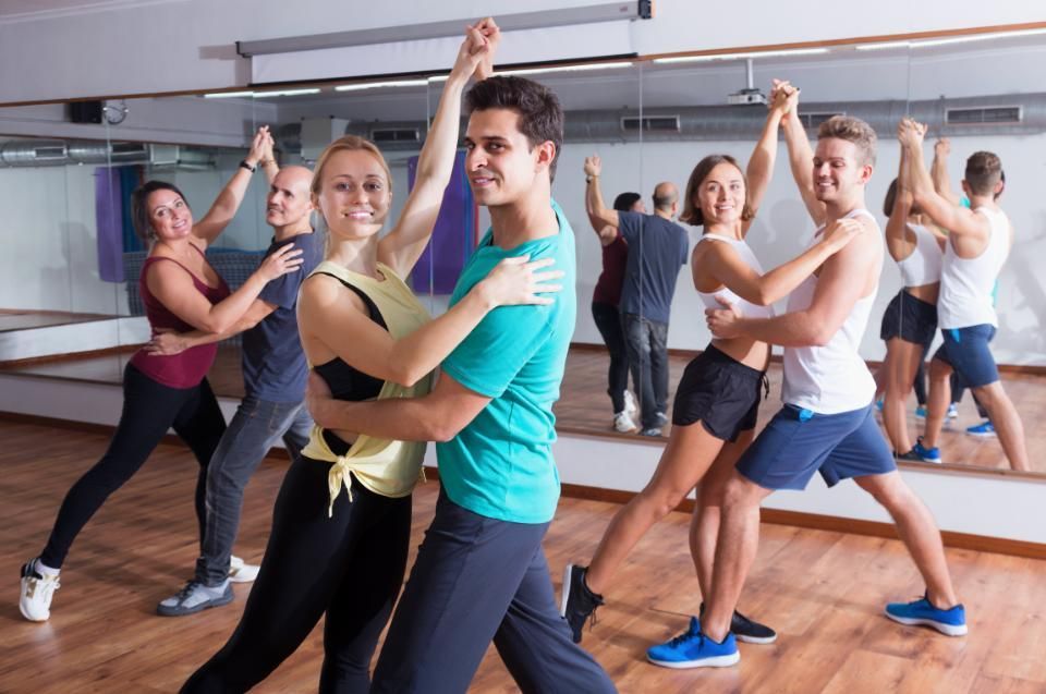 Eine Gruppe von Frauen tanzt zusammen in einem Fitnessstudio. ADTV Tanzschule Baulig UG