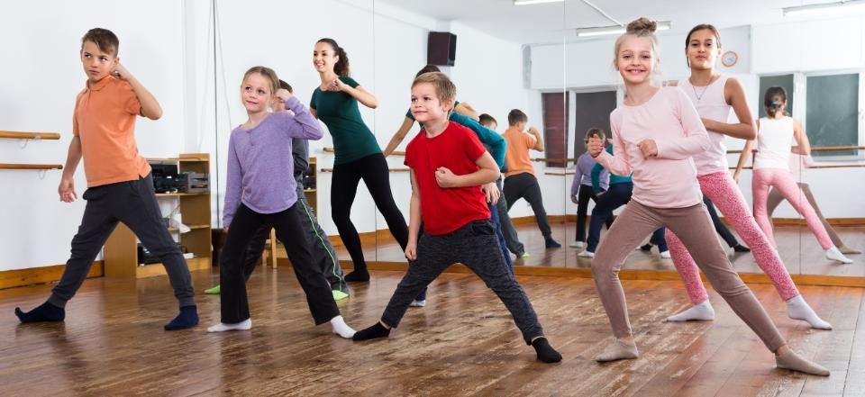 Eine Gruppe Frauen tanzt in einer Turnhalle. ADTV Tanzschule Baulig UG