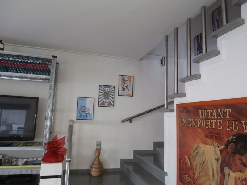 Μοντέρνα σκάλα σαλονιού με τοιχογραφία, τηλεόραση και πλαισιωμένη αφίσα στα δεξιά