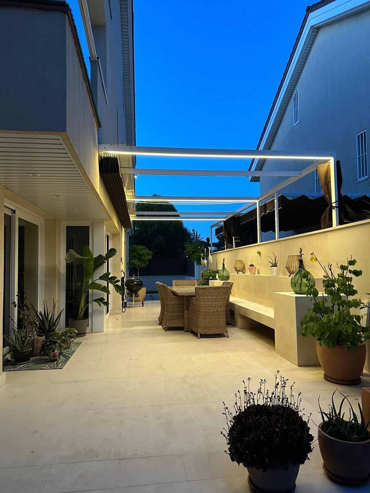 Un patio con sillas, un banco y plantas en macetas.