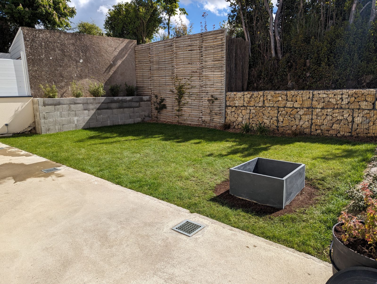 Aménagement d'un jardin avec pose de pelouse et réalisation d'un mur en pierres