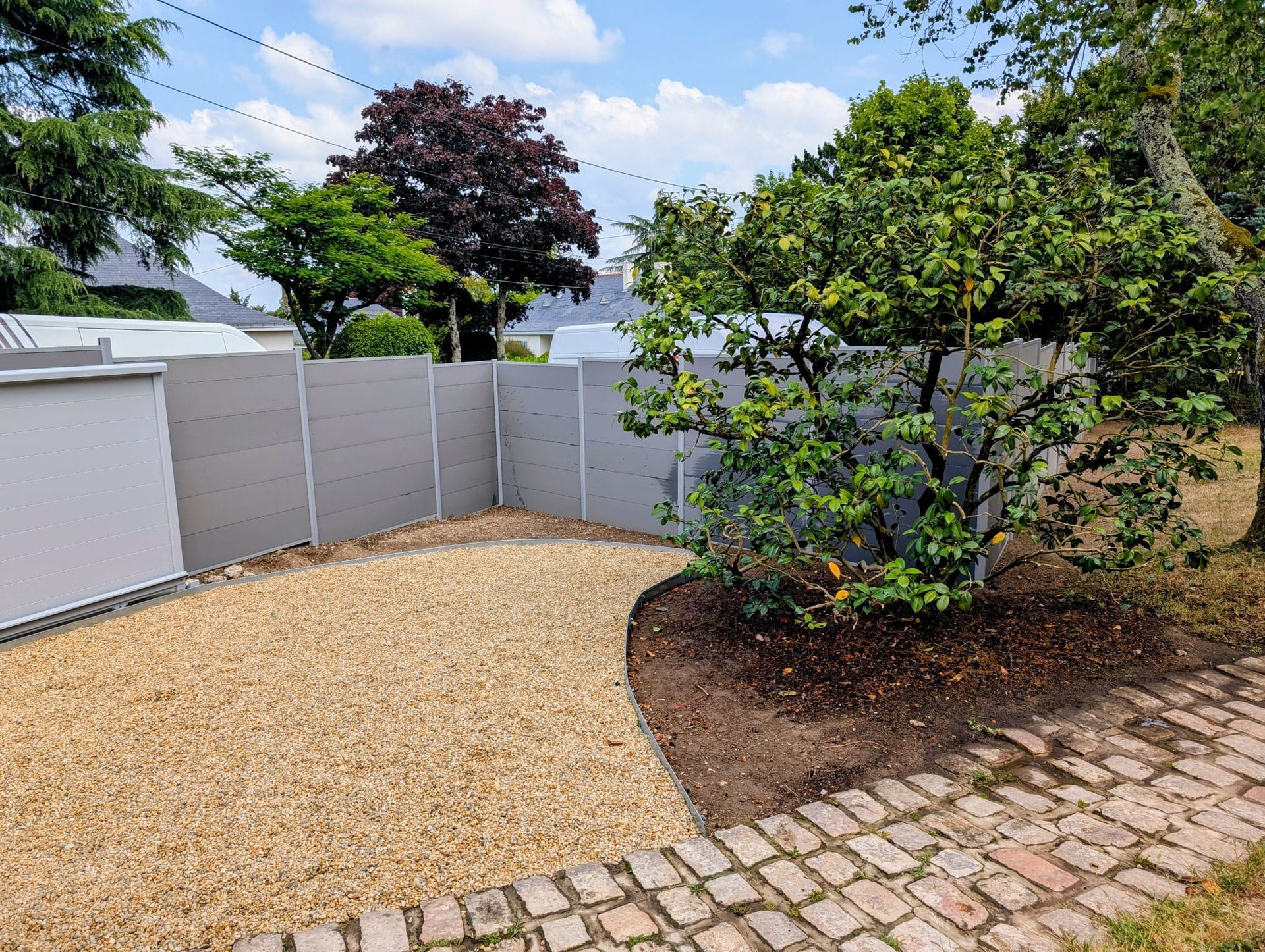 Installation de la clôture d'une maison individuelle avec un massif paysager