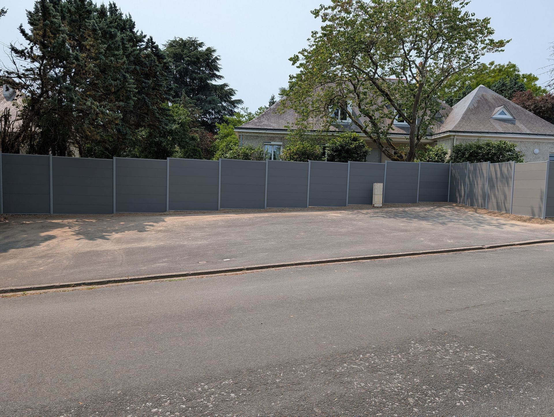 Vue d'ensemble de la clôture occultante de couleur grise sur le terrain d'une maison individuelle