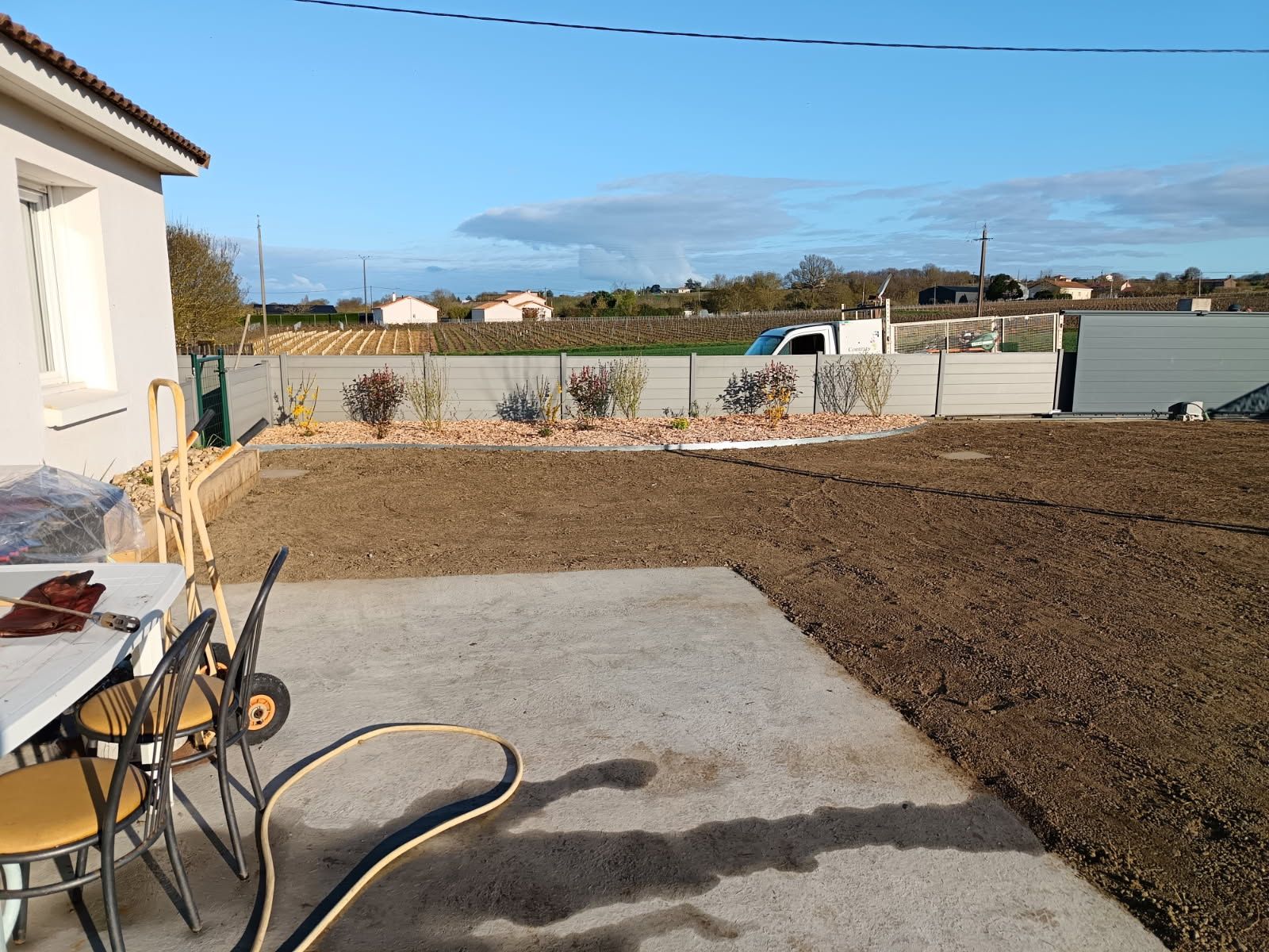 Prise de vue de la création d'un jardin depuis la terrasse de la maison