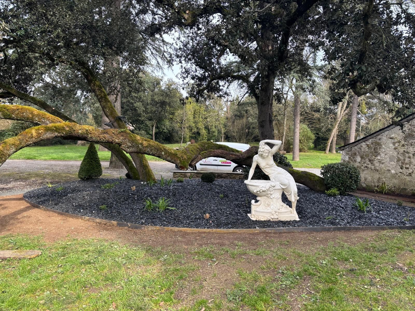 Création d'un massif paysager au cœur d'un jardin, une statue en marbre trône en son centre