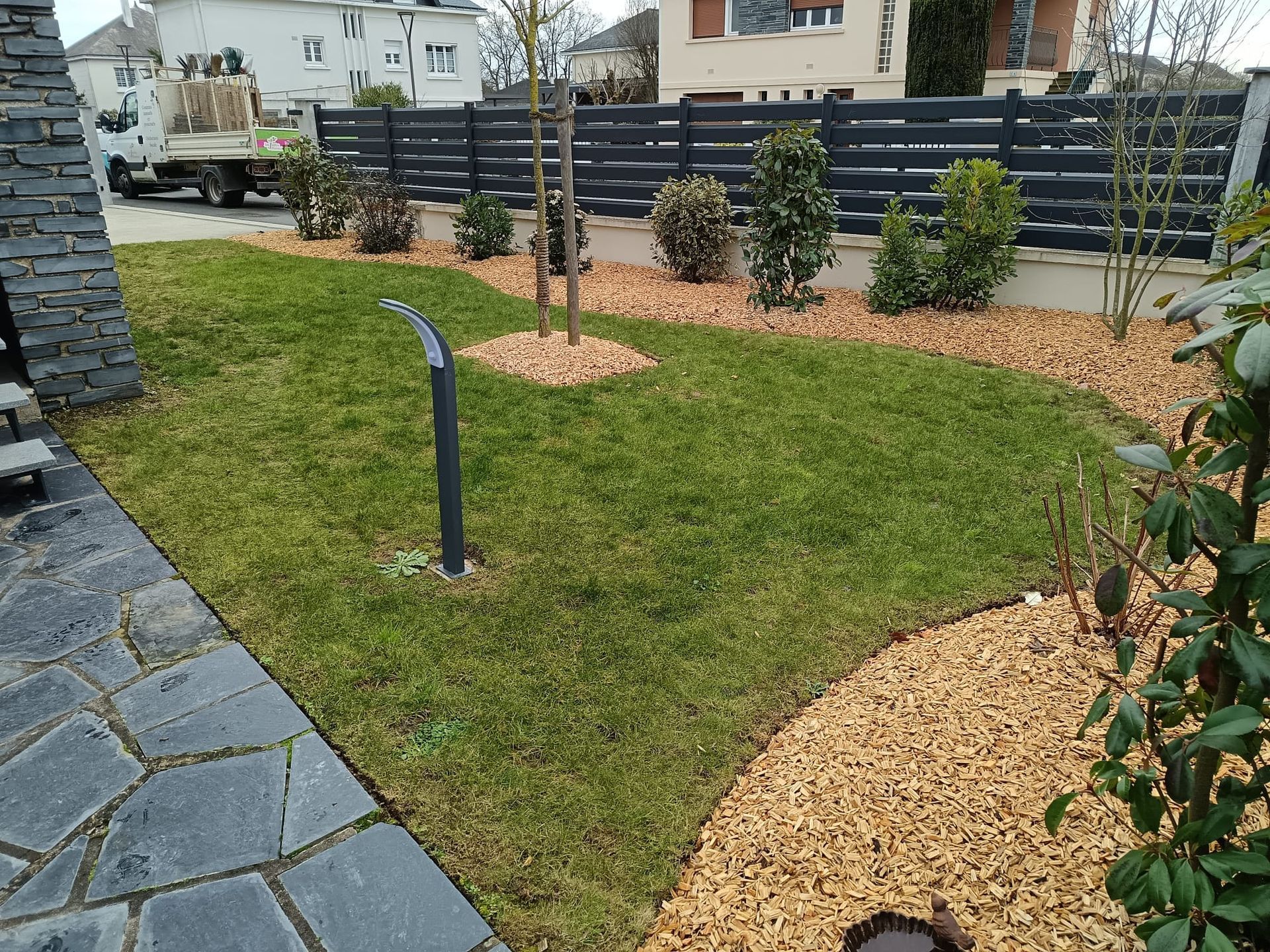 Jardin aménagé avec éclairage solaire et massif en bordure du terrain