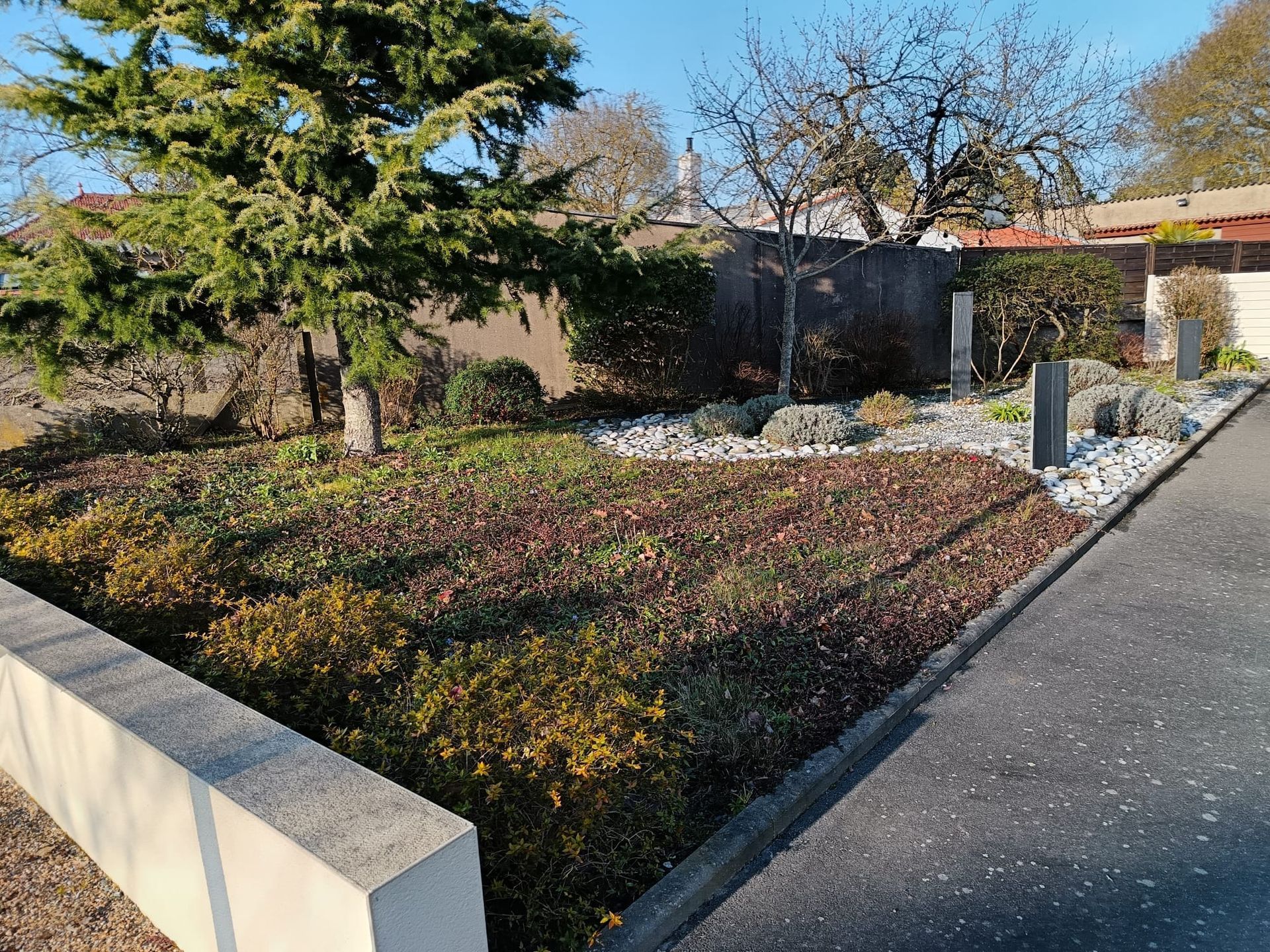 Entretien d'un jardin entièrement aménagé longeant une voie carrossable