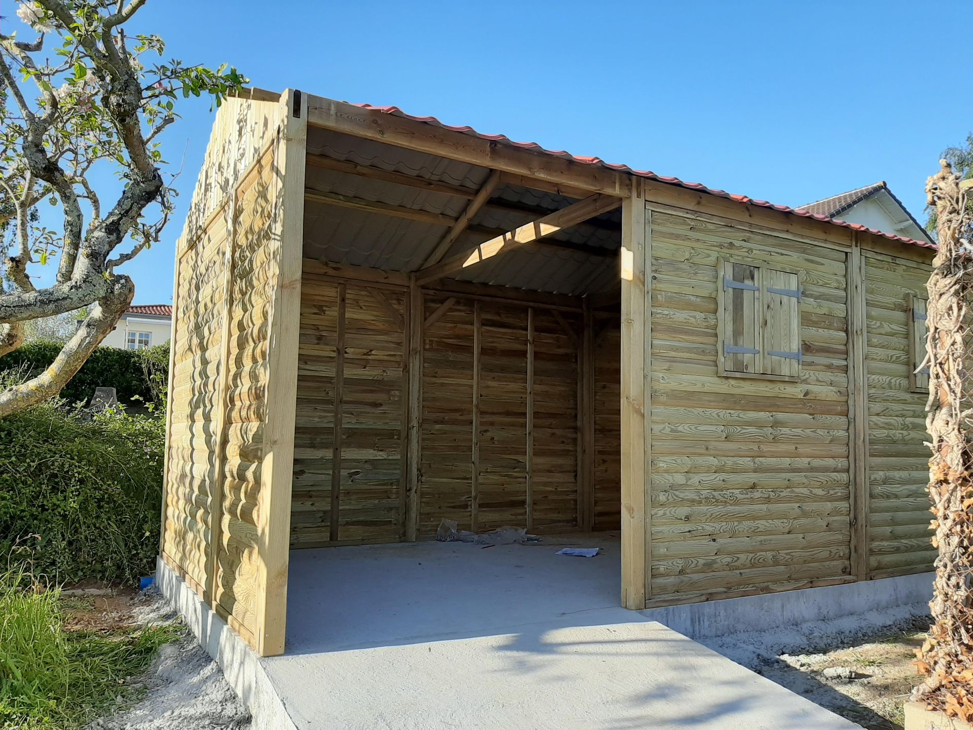 Installation d'un abri de jardin en bois avec de petitres fenêtres