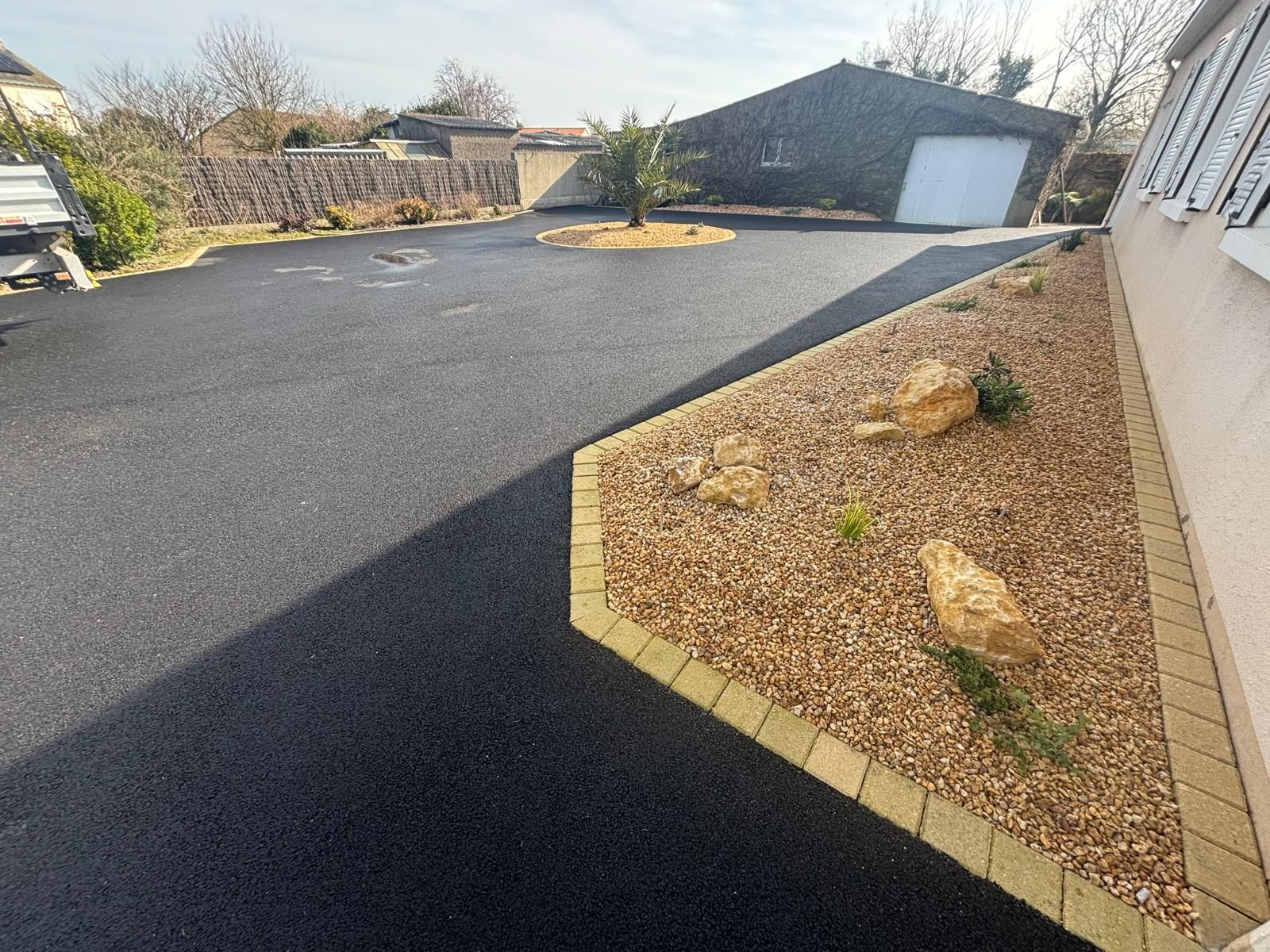 Vue d'ensemble sur les massifs paysagers d'une maison individuelle sur son allée carrossable