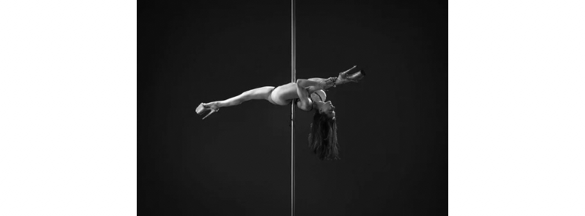 Una mujer en pose sobre un poste.