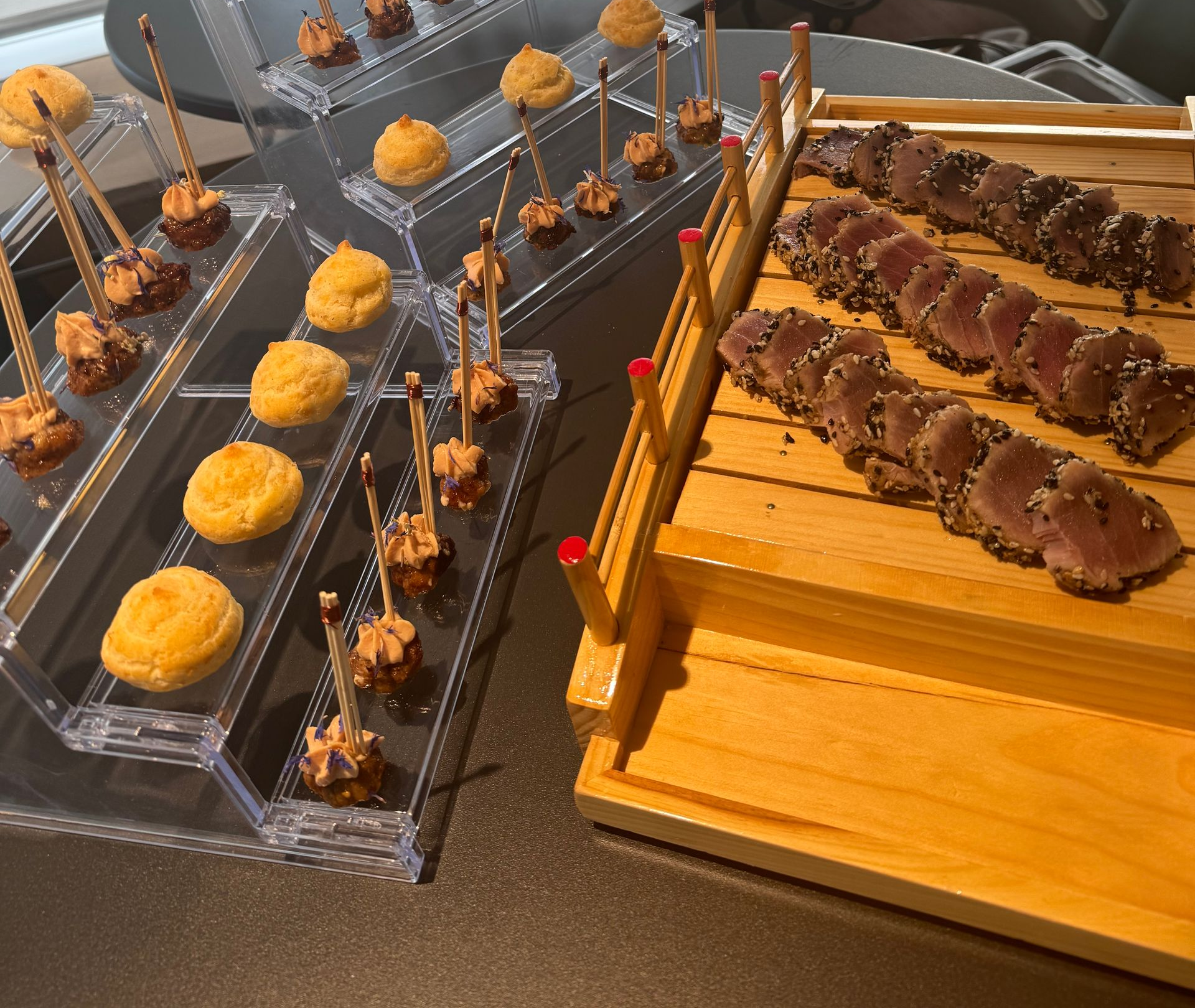 Brochettes de desserts assorties et pâtisseries garnies d'orange présentées sur un buffet.