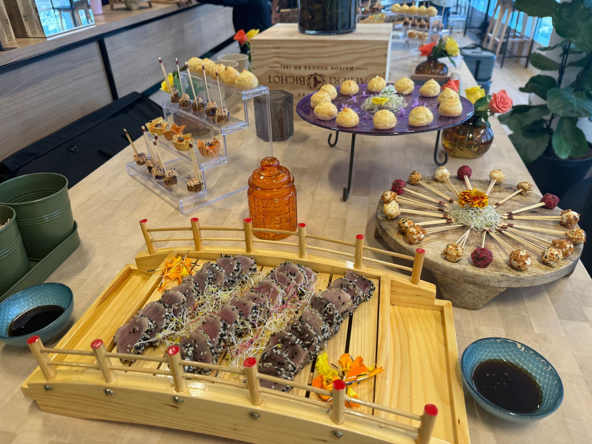 Buffet avec assortiment de desserts, pâtisseries et tasses à thé disposés sur des plateaux et des plats.