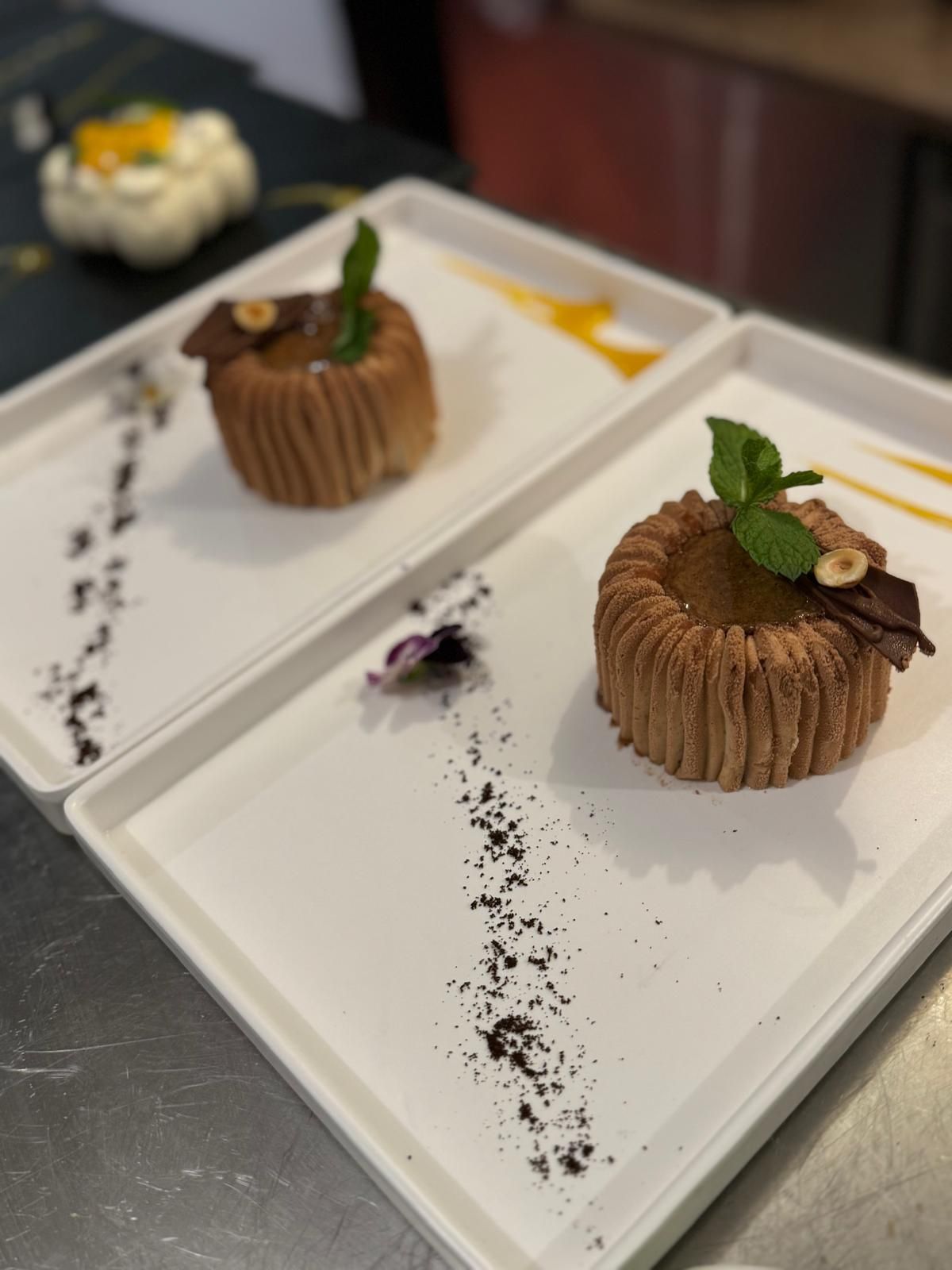 Desserts au chocolat à l'assiette, garnis de menthe, présentés sur des plats rectangulaires blancs, servis dans un restaurant.