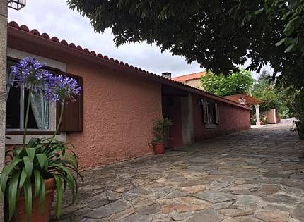 Comedor con mesa, sillas, sofá y grandes ventanales con vistas.