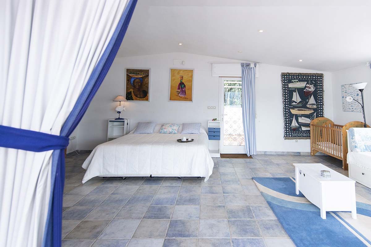 Comedor con mesa, sillas, sofá y grandes ventanales con vistas.