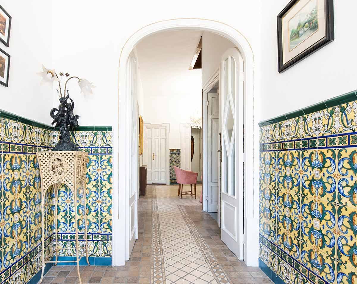 Comedor con mesa, sillas, sofá y grandes ventanales con vistas.