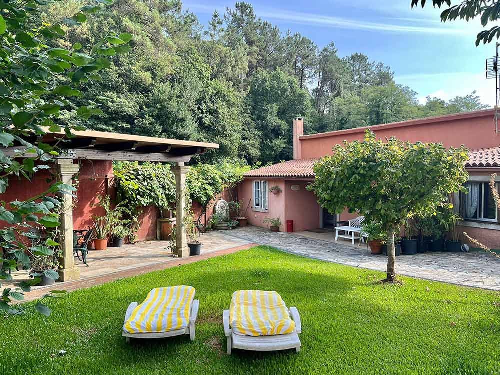 Comedor con mesa, sillas, sofá y grandes ventanales con vistas.