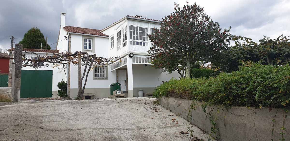 Comedor con mesa, sillas, sofá y grandes ventanales con vistas.