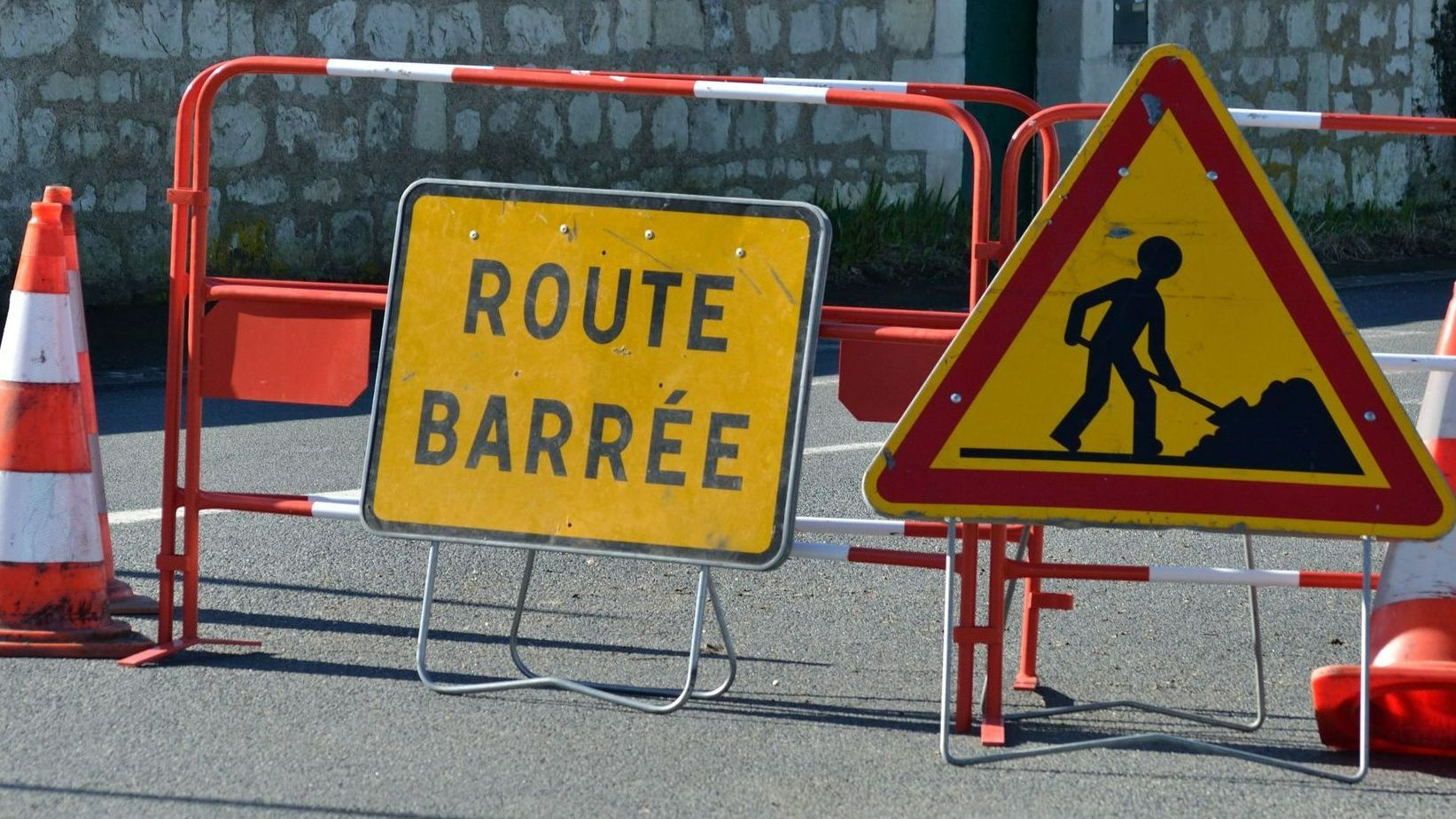 Un panneau route barrée et un panneau chantier en cours