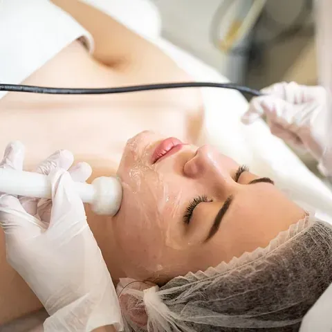 Una mujer está recibiendo un tratamiento facial en un salón de belleza.