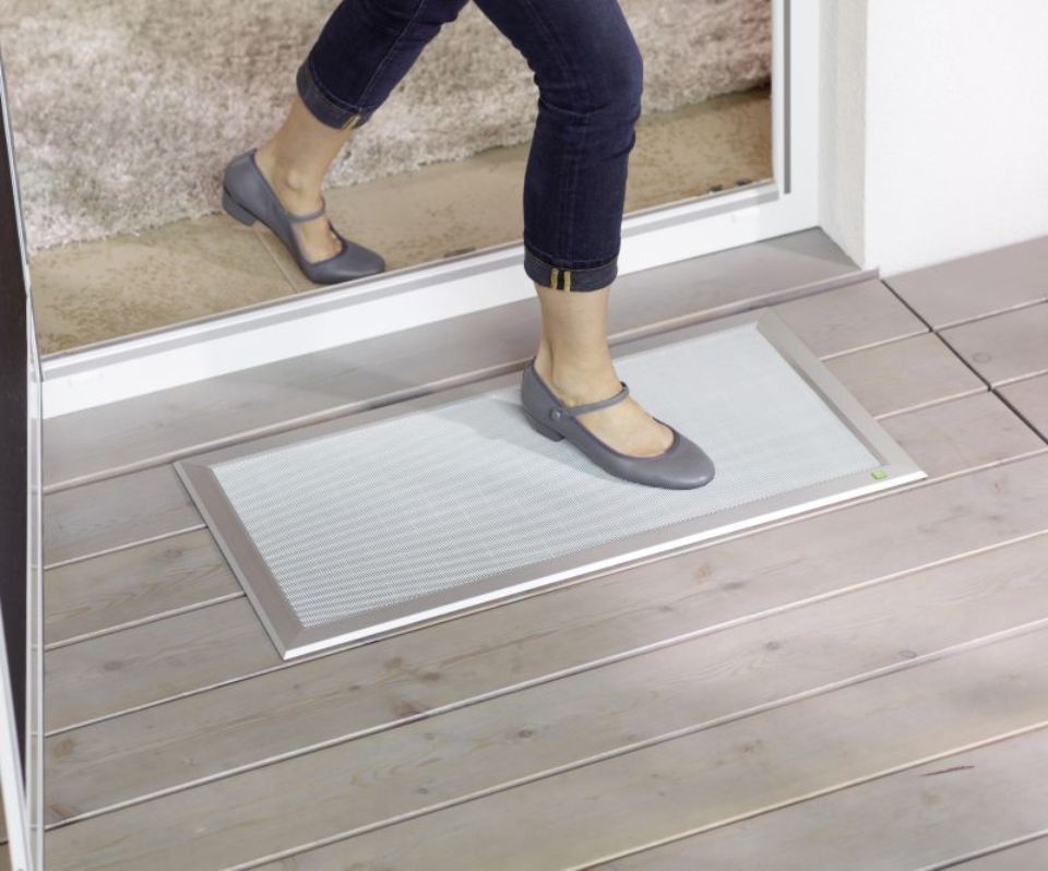 Füße laufen über ein Fliegenschutzgitter auf dem Boden