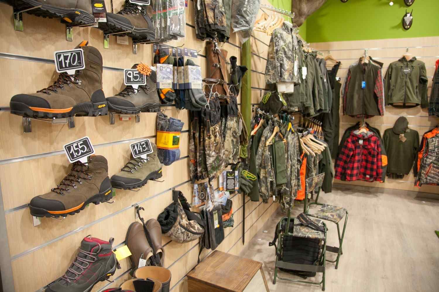 Exhibición de tienda de ropa de caza con botas, calcetines y ropa de camuflaje.